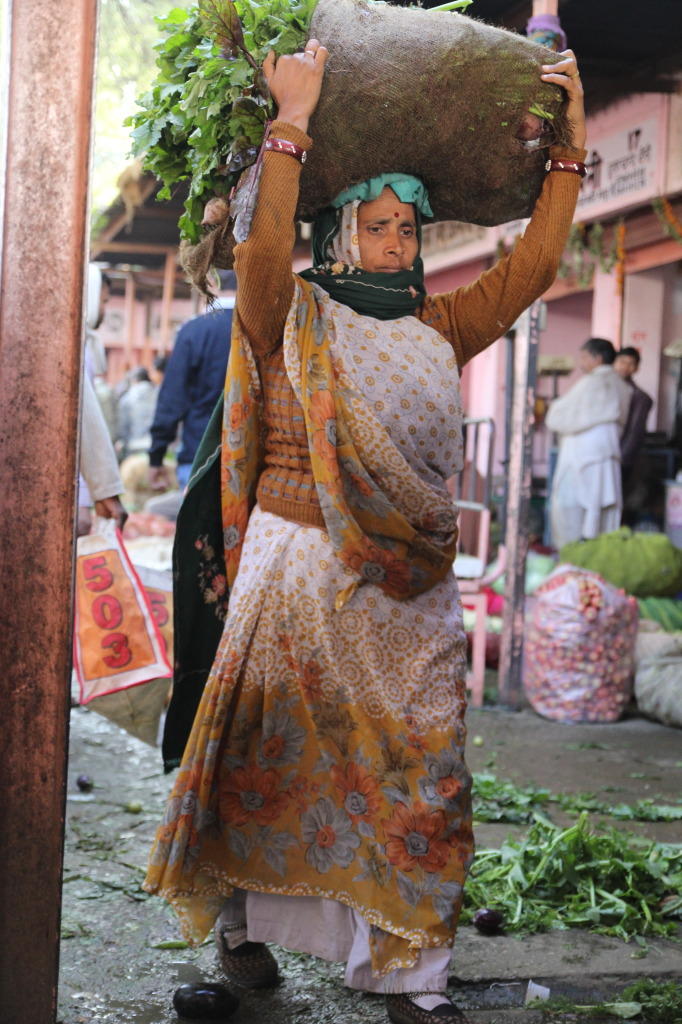 Woman carrying produce in market in Jaipur, India. Copyright Mel Prax 2014.